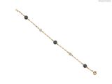 un gros plan d'un bracelet composé de perles noires sur fond blanc