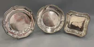 three silverplated dishes, each with a raised edge