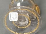 a glass vase with a gold decoration on it