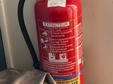 a fire extinguisor sitting on the floor next to a blanket