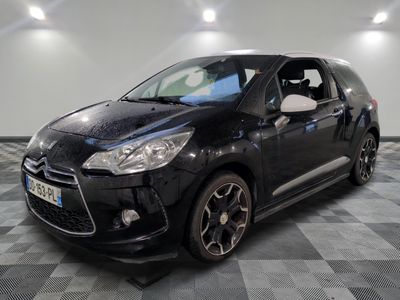 the small black car is parked on a checkered floor