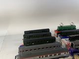 several model trains are lined up in a row on a white surface