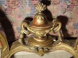 a gold vase sitting on top of a table next to a mirror