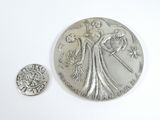 a close up of a coin and a small coin on a white surface