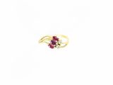 gros plan d'une bague en or avec une pierre en rubis