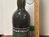 une bouteille d'alcool posée sur une table à côté d'une règle