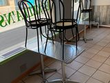 tables and chairs in front of a window in a restaurant