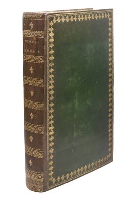 un vieux livre à la couverture verte posé sur une surface blanche