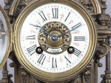 a gold clock with roman numerals on the face