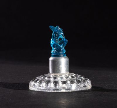 a close up of a small glass figurine on a black surface