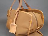 tan leather handbag with tan leather handles and a tan leather shoulder strap