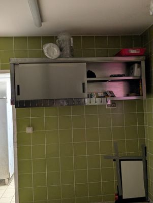 une salle de bains carrelée de vert, avec un lavabo et un miroir