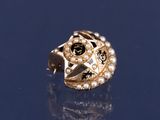 une image représentant une bague en or ornée de perles et d'une étoile