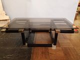 une photo d'une table basse en verre et en métal posée sur un parquet en bois massif