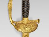 a close up of a gold and black sword on a white background