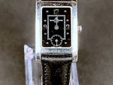 une photo d'une montre exposée sur un présentoir transparent