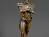 une statue en bronze représentant un homme coiffé d'un casque