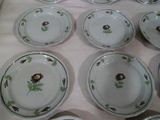 many plates with flowers on them sitting on a table