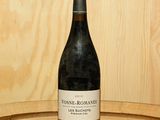 une bouteille de vin posée sur un tonneau en bois