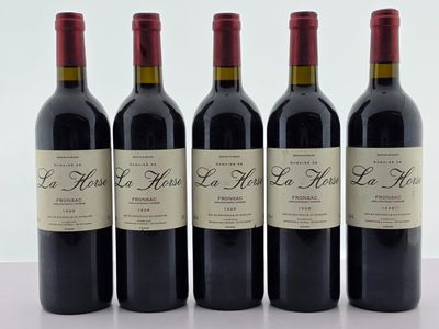 quatre bouteilles de vin rouge sont alignées sur une table