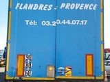 a blue and yellow truck parked on the side of the road