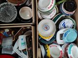 une boîte remplie de tasses et de sauces posée par terre