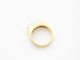 a close up of a gold ring on a white surface