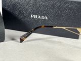 prada sunglasses with box and tie on a table
