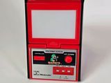 une console Nintendo rouge posée sur une surface blanche