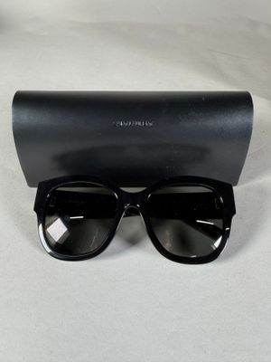 des lunettes de soleil à monture noire, accompagnées d'un étui noir, posées sur une surface blanche