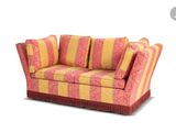 a red and yellow striped couch with pillows on it