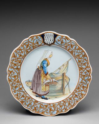 une image représentant une assiette décorative sur laquelle figure une femme dans un bateau
