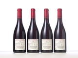 three bottles of red wine are lined up on a table