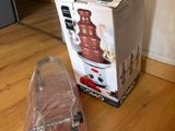 une fontaine à chocolat posée par terre à côté d'un sac en plastique