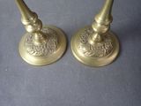 pair of antique brass candlesticks on a blue background