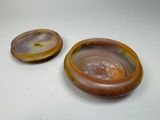 two brown and yellow bowls sitting on top of a white table