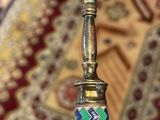 a gold candle holder with a colorful design on it