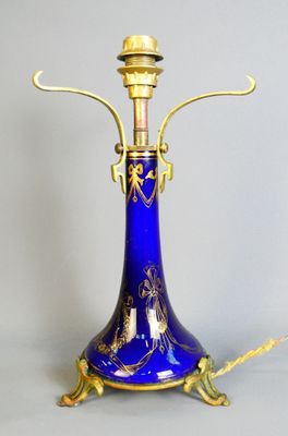 a blue vase with a gold handle on a stand