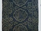 une image représentant un tapis noir orné d'un motif doré
