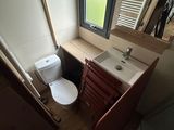 a small bathroom with a toilet and a sink under a window