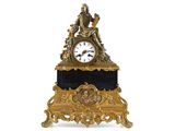 a clock that is sitting on a stand with a statue on top of it