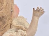 someone is holding a small doll in their hands on a white background