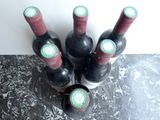 several bottles of wine are lined up on a counter top