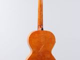 a wooden guitar hanging from a string on a white background