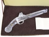 a glass gun that is in a box on a table