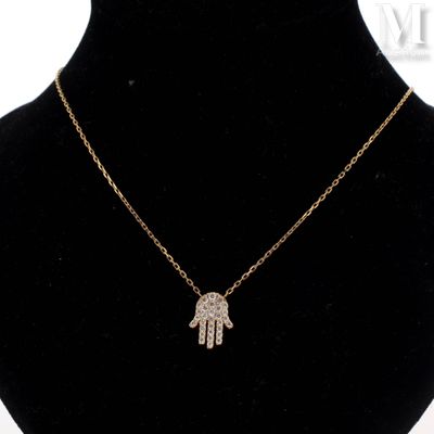a gold necklace with a hamsa hand pendant on a mannequin neck