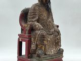a statue of a man sitting on a red chair