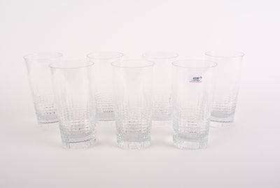 quatre verres transparents sont alignés sur une surface blanche