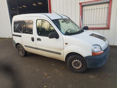 une petite camionnette blanche garée devant un bâtiment