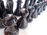 a lot of chess pieces that are lined up on the table